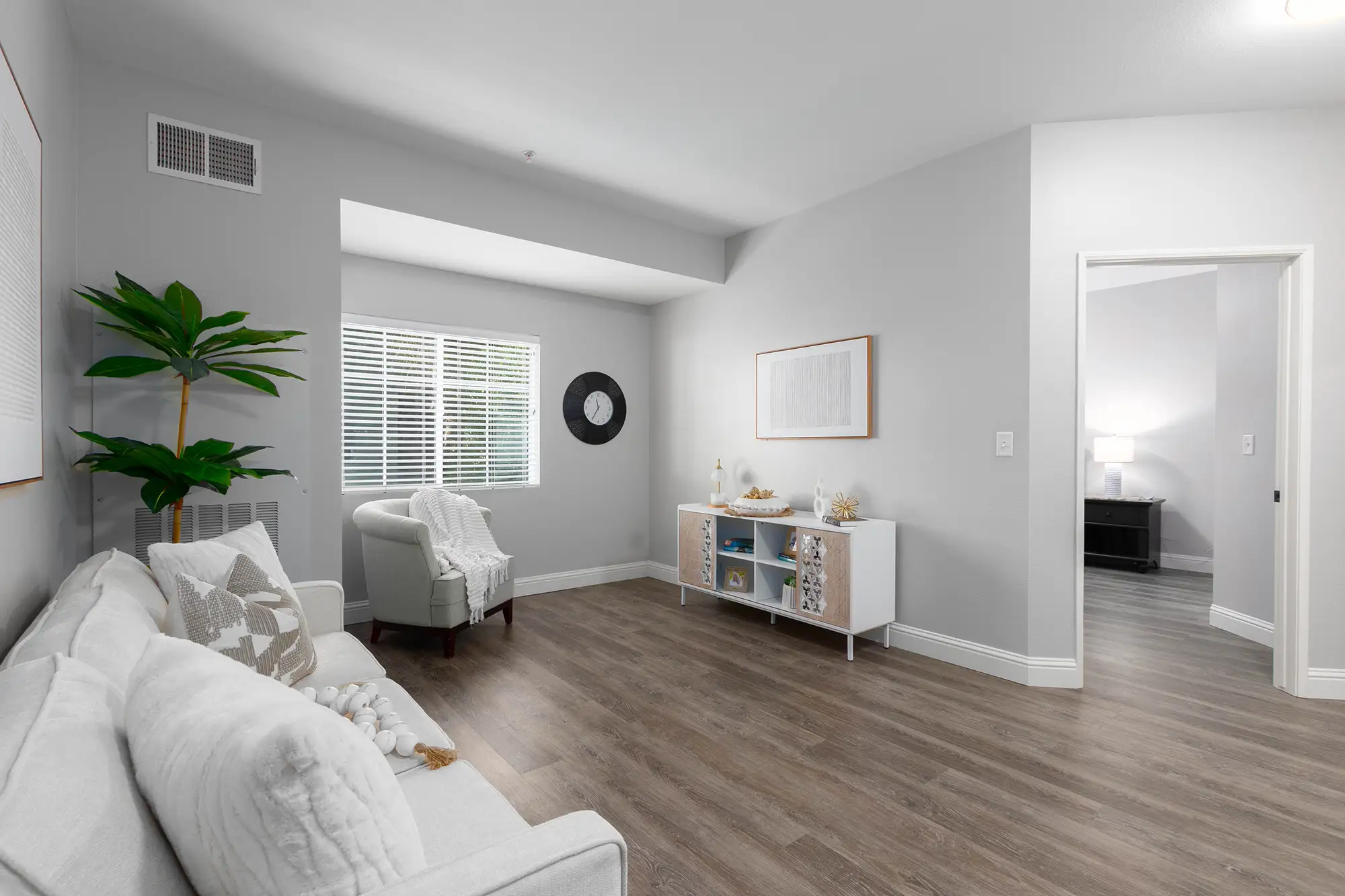 sophisticated living room with a black leather couch and brown arm chairs