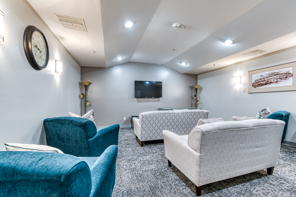 room with recliner chairs and sofas with TV